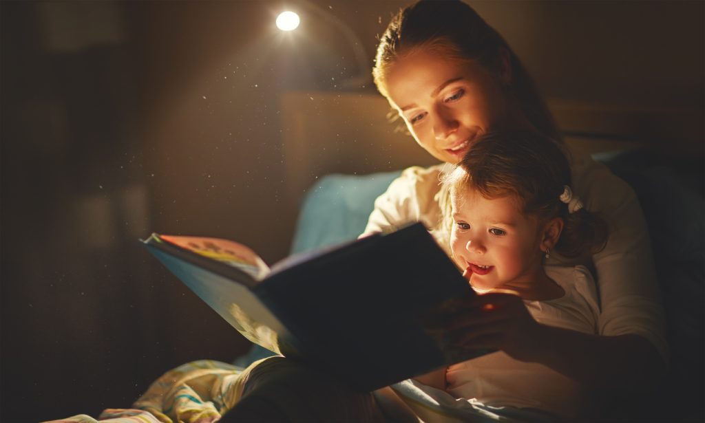 Reading bedtime story to little girl